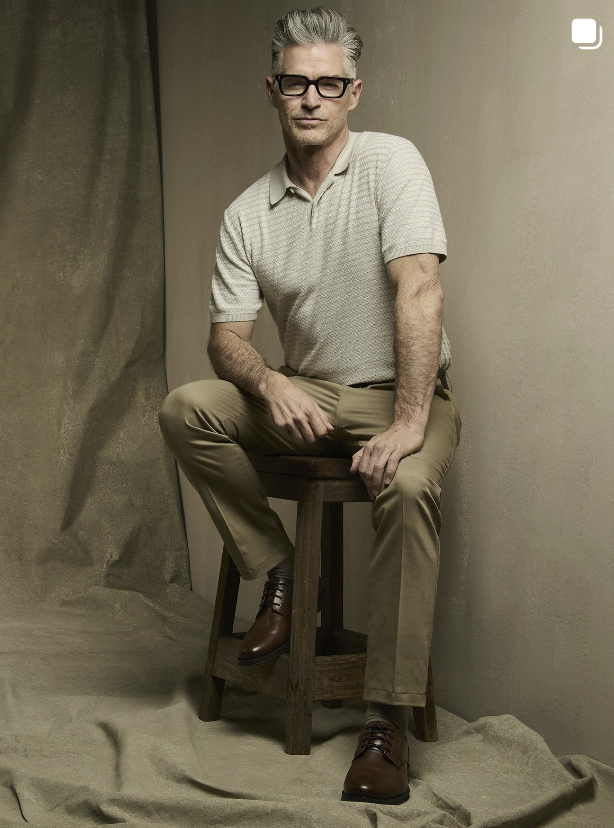 A minimalist studio backdrop featuring draped, earthy, sand-colored canvas fabric that creates subtle, soft folds.